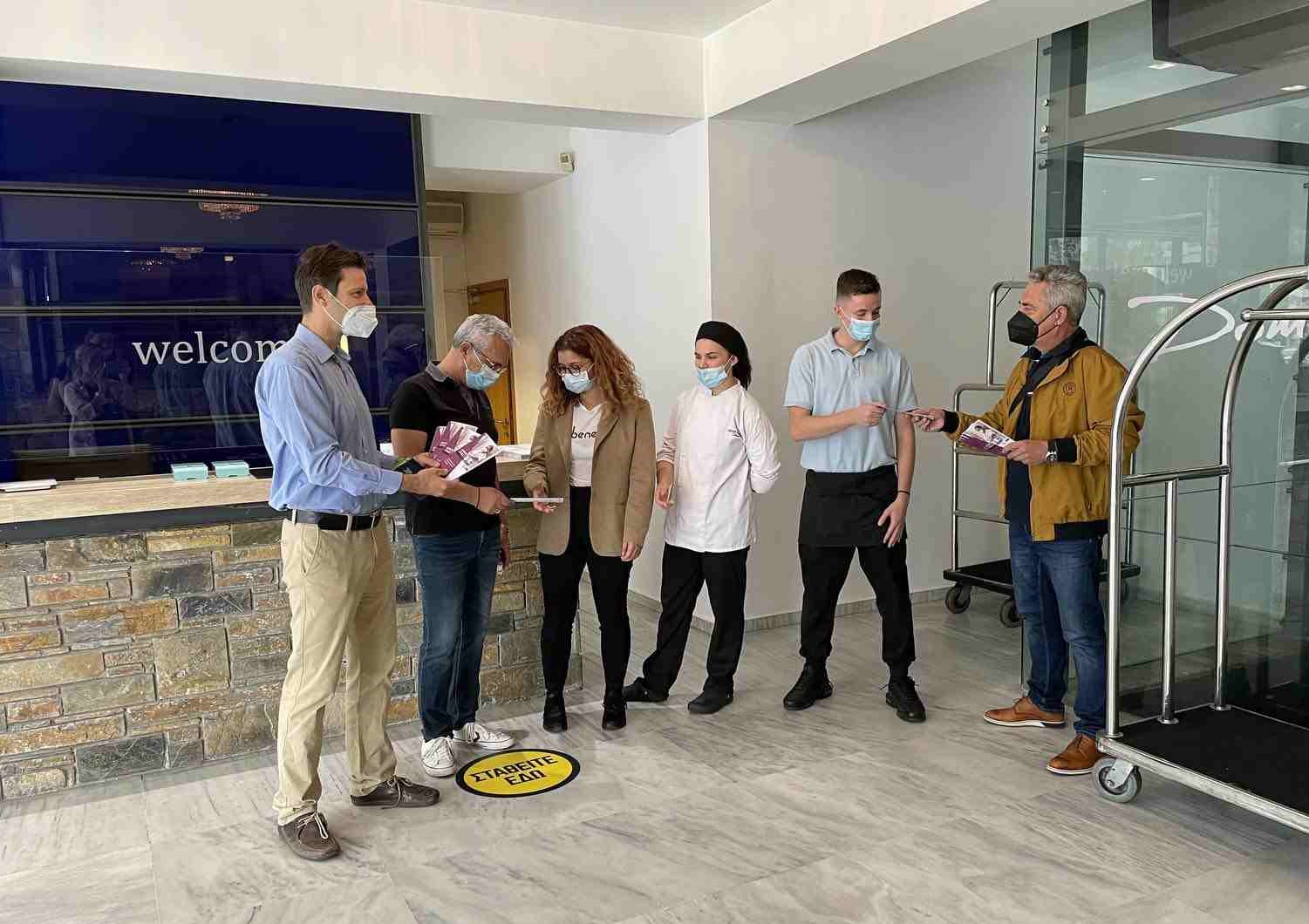 Photo of inspectors talking to seasonal workers in a hotel whilst handing out leaflets informing them of their rights.