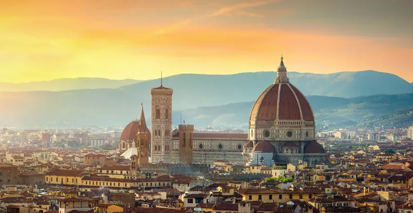 Panoramic view of Florence at sunset, featuring the iconic Duomo and city skyline.
